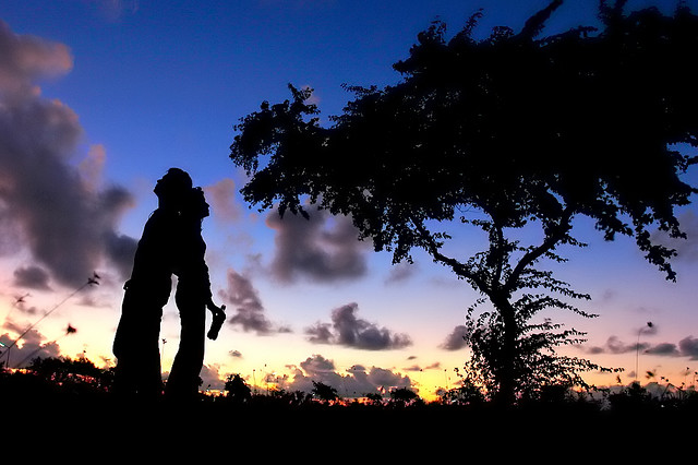 Two people standing against sunset backdrop
